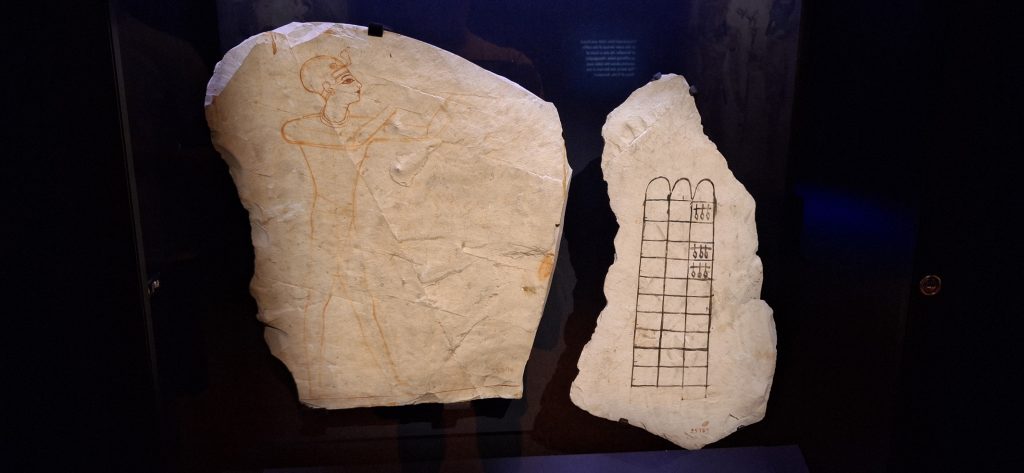 Ostracas con el juego de senet y un boceto de un faraón realizando una ofrenda